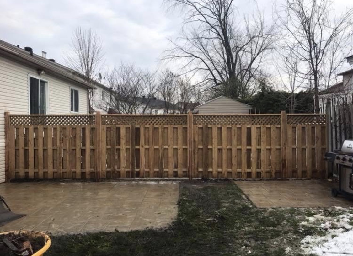 New wood privacy fence and stamped concrete patio in backyard